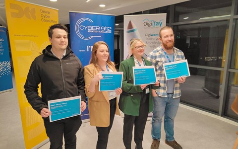 Four students standing with certificates