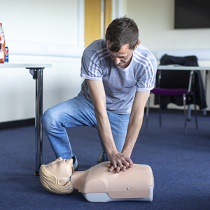 Student performing first aid on CPR dummy